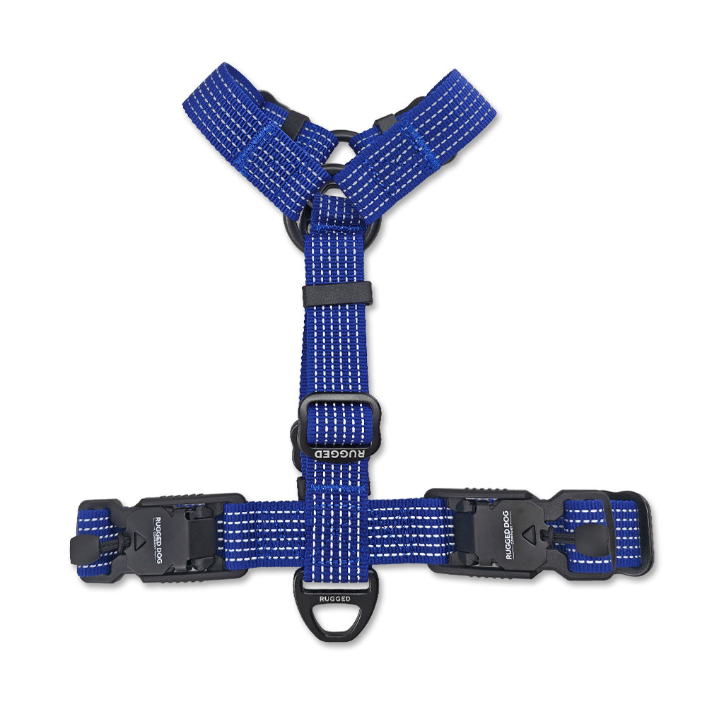 Top-down view of Navy Rugged Dog Company no-pull harness showing dual magnetic FIDLOCK V-Buckles, aircraft-grade aluminum back D-ring for leash attachment, adjustable polyester webbing, Rugged-branded metal sliders and high-visibility reflective stitching