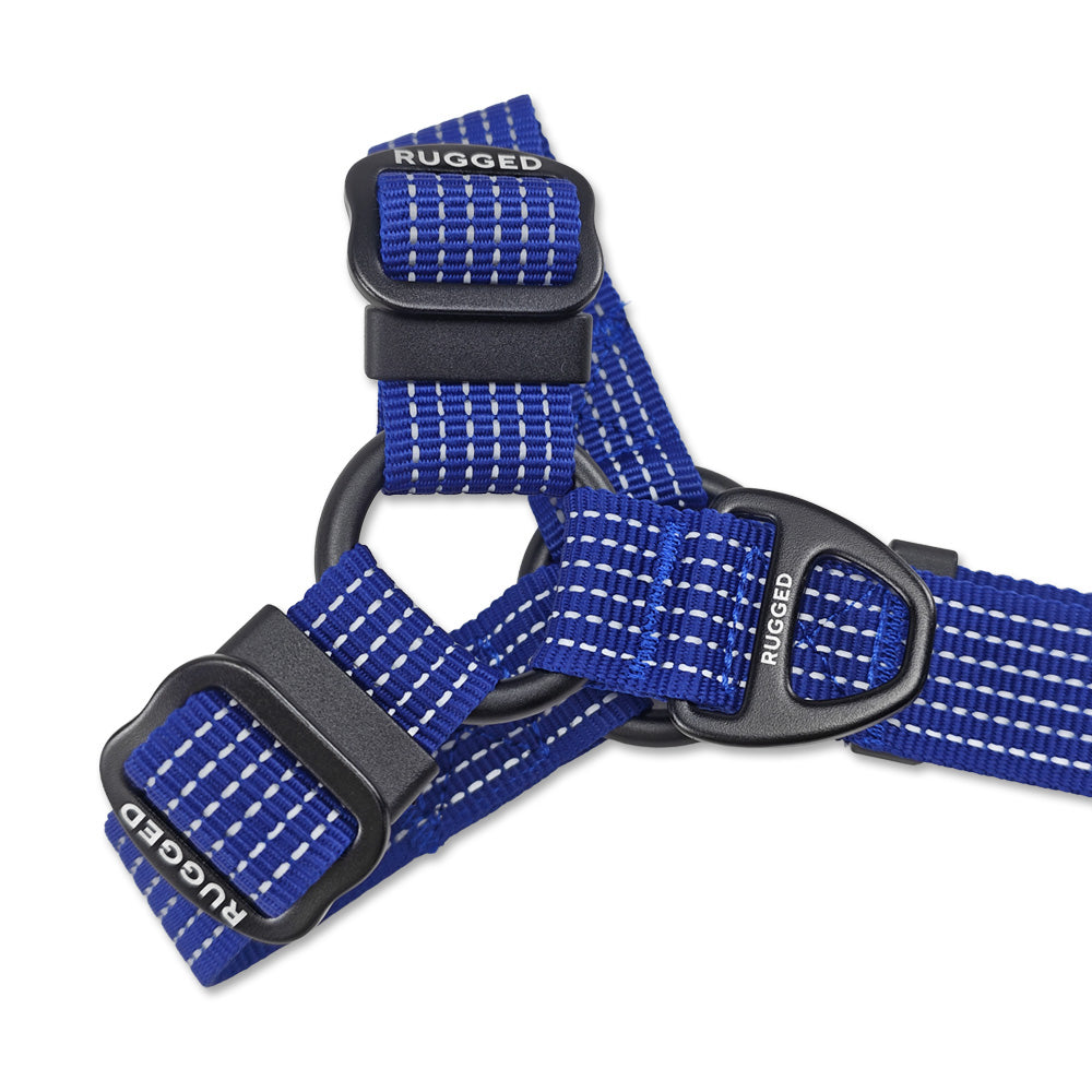 Close-up of Navy Rugged Dog Company no-pull harness showing reinforced metal O-ring construction, large aircraft-grade aluminum D-ring, Rugged-branded metal adjustment sliders, durable polyester webbing and high-visibility reflective stitching